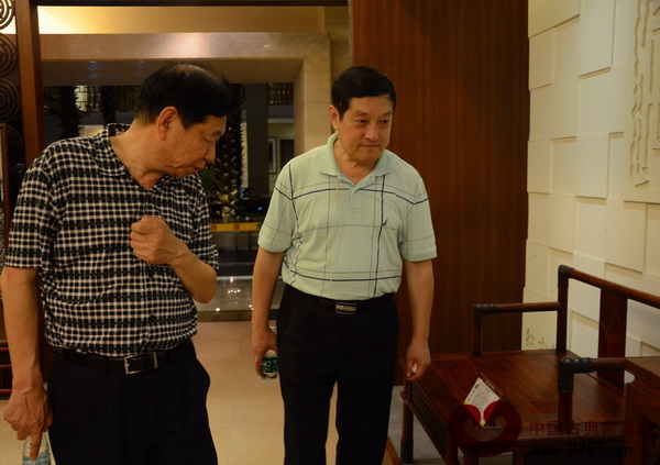 全国工商联民间文物艺术品商会会长宋建文（左），全国工商联民间文物艺术品商会秘书长肖秉侠在鉴赏红古轩展厅内的精品家具
