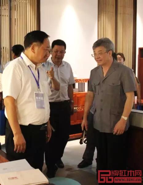 在首届中国新中式红木家具大会上，中山市政协主席丘树宏（右一）视察忆古轩展厅并与刘定杰（左一）亲切交流