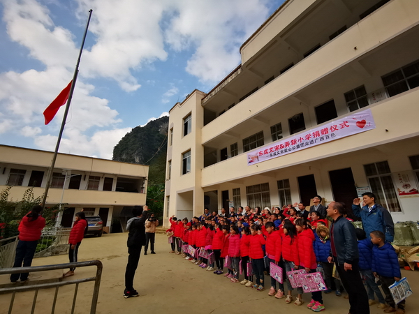 穿上了新棉衣、领到了新文具的同学们，和东成红木爱心助学公益团一起进行升旗仪式